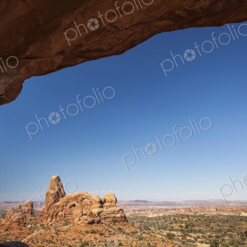 Scenic view of Turret Arch framed by the sandstone curve of North Window Arch in…