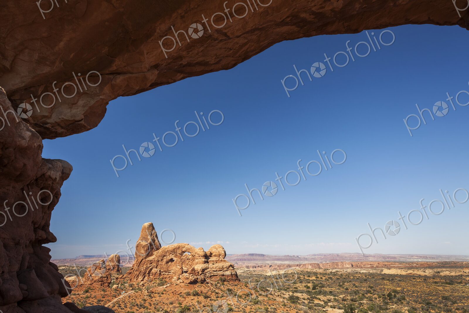 Scenic view of Turret Arch framed by the sandstone curve of North Window Arch in…