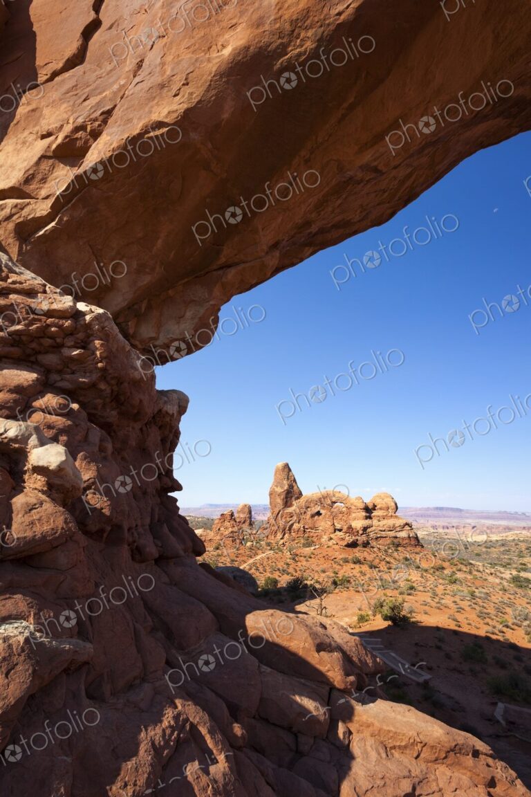 Scenic view of Turret Arch framed by the sandstone curve of North Window Arch in…