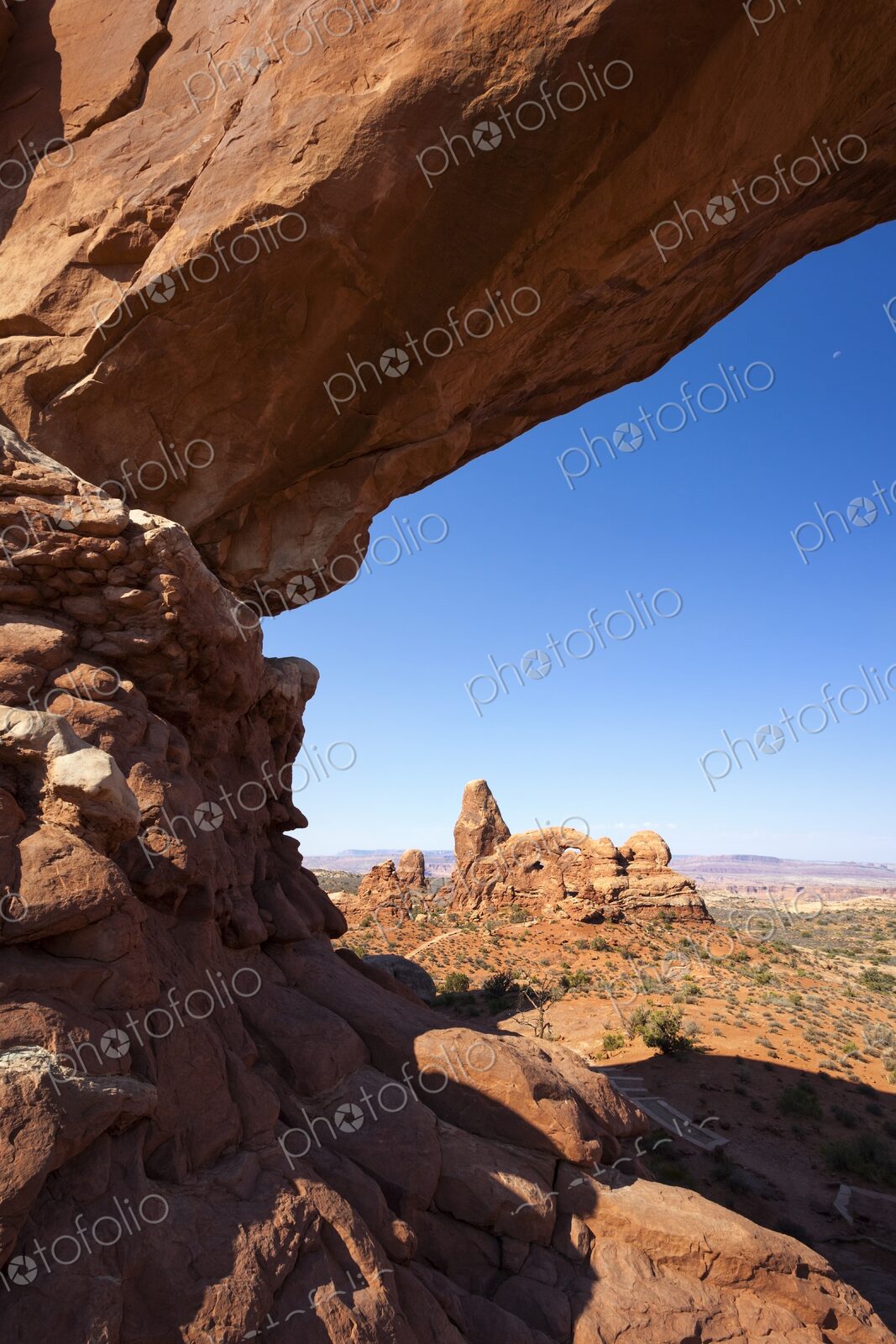 Scenic view of Turret Arch framed by the sandstone curve of North Window Arch in…
