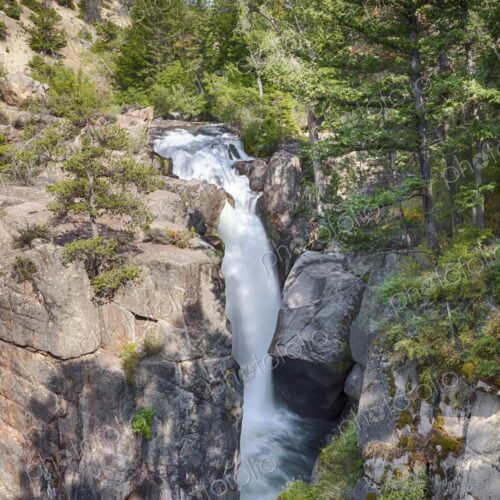 Scenic waterfall cascading through rocky cliffs and lush forest at Shell Falls in… Scenic waterfall cascading through rocky cliffs and lush forest at Shell Falls in…