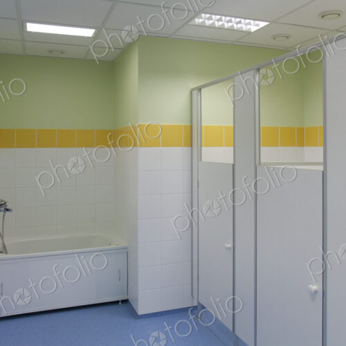 School Restroom Stalls, yellow paintwork and white doors, blue floor