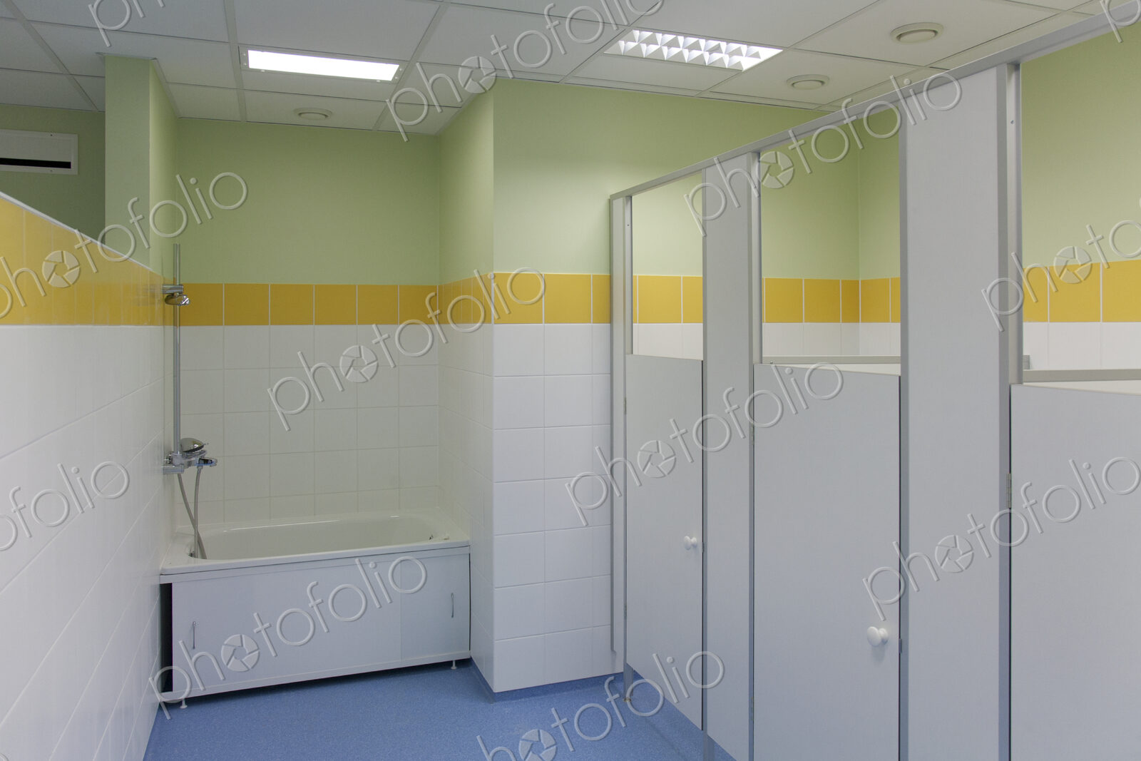 School Restroom Stalls, yellow paintwork and white doors, blue floor