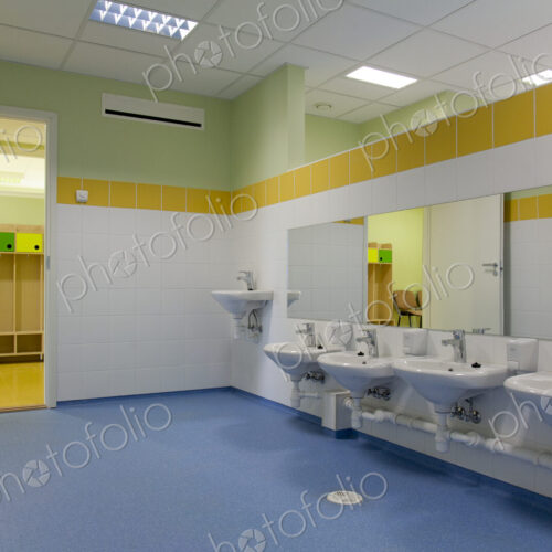 School Restroom, modern style with yellow paint and blue flooring
