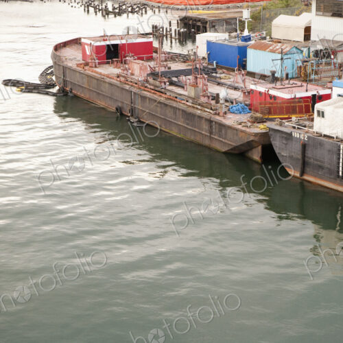Seaport with freight barges moored for unloading.