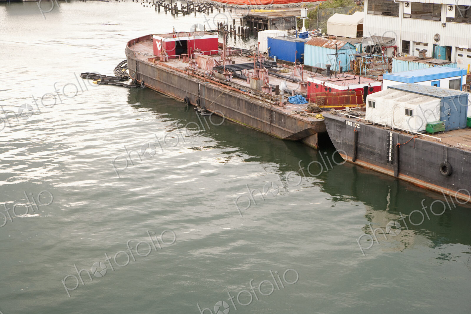 Seaport with freight barges moored for unloading.
