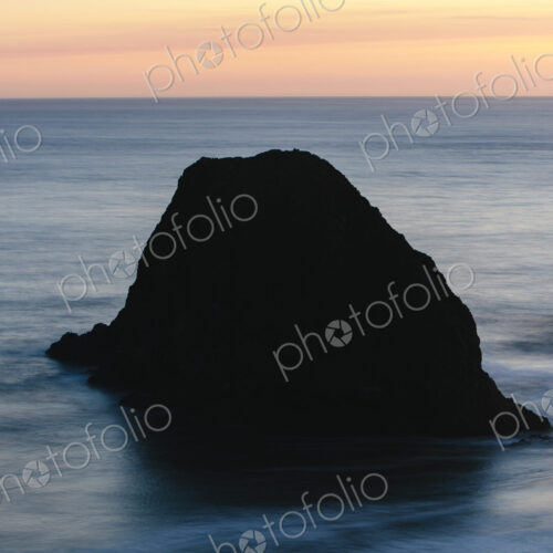 Seastack in vast ocean at dusk Seastack in vast ocean at dusk