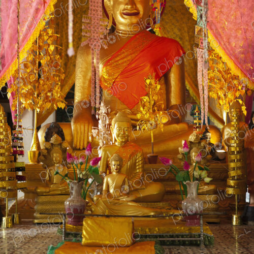 Seated Buddha statues at an altar at a Wat in the Angkor Temples complex.