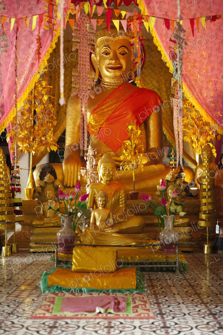 Seated Buddha statues at an altar at a Wat in the Angkor Temples complex.