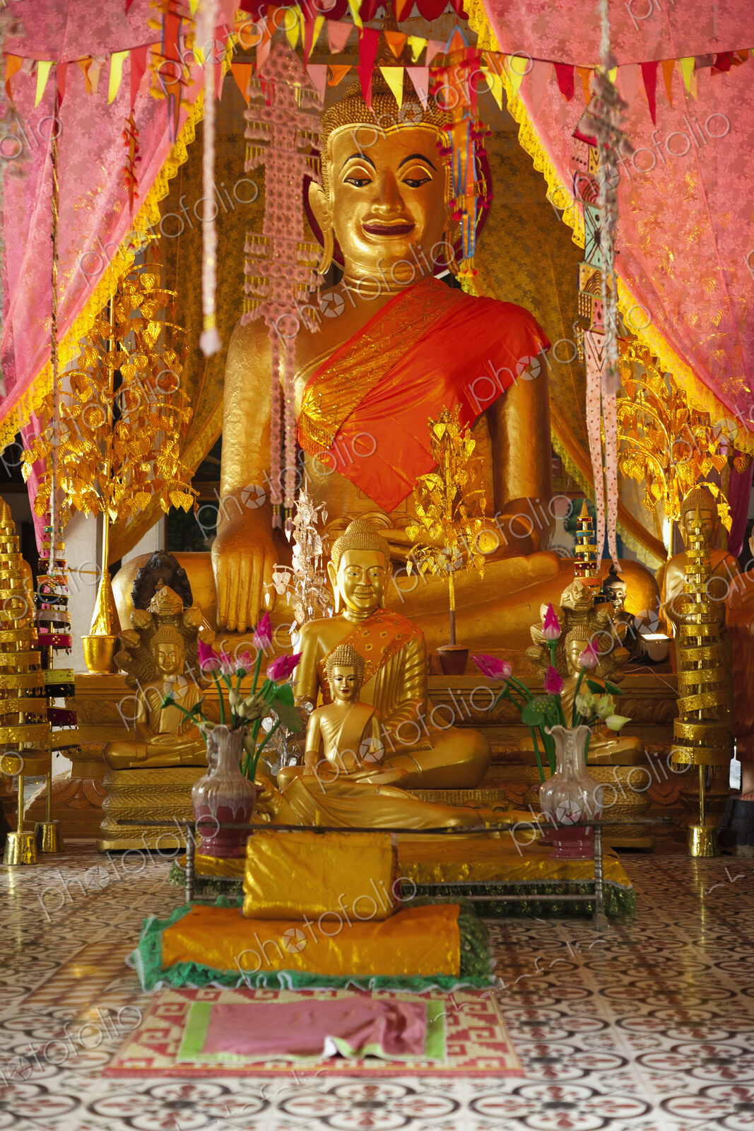 Seated Buddha statues at an altar at a Wat in the Angkor Temples complex.
