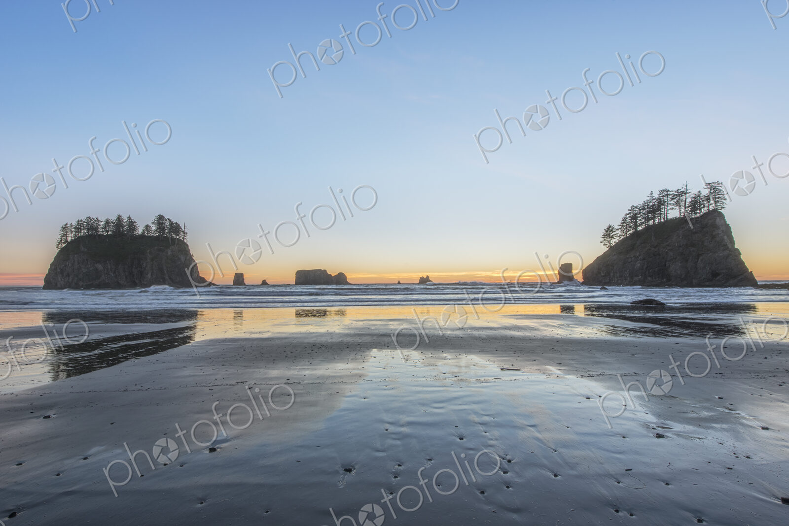 Second Beach at low tide, seastacks offshore silhouetted at sunset.