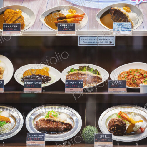 Selection of Japanese foods on oval plates displayed on shelves.