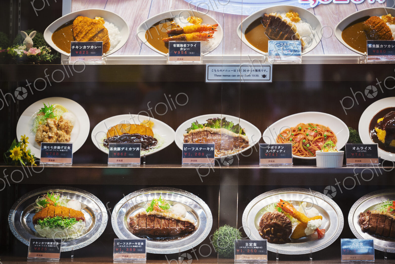 Selection of Japanese foods on oval plates displayed on shelves.