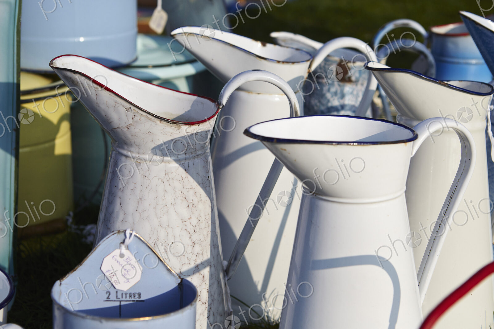Selection of white vintage enamel jugs for sale.