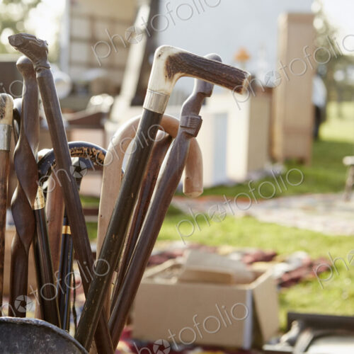 Selection of wooden canes and walking sticks for sale at an open air flea market stall.