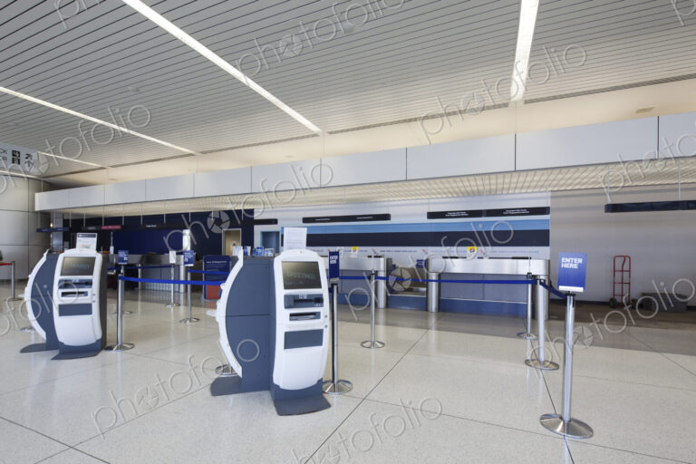 Self check-in desks and traditional baggage check in desks in an empty airport.