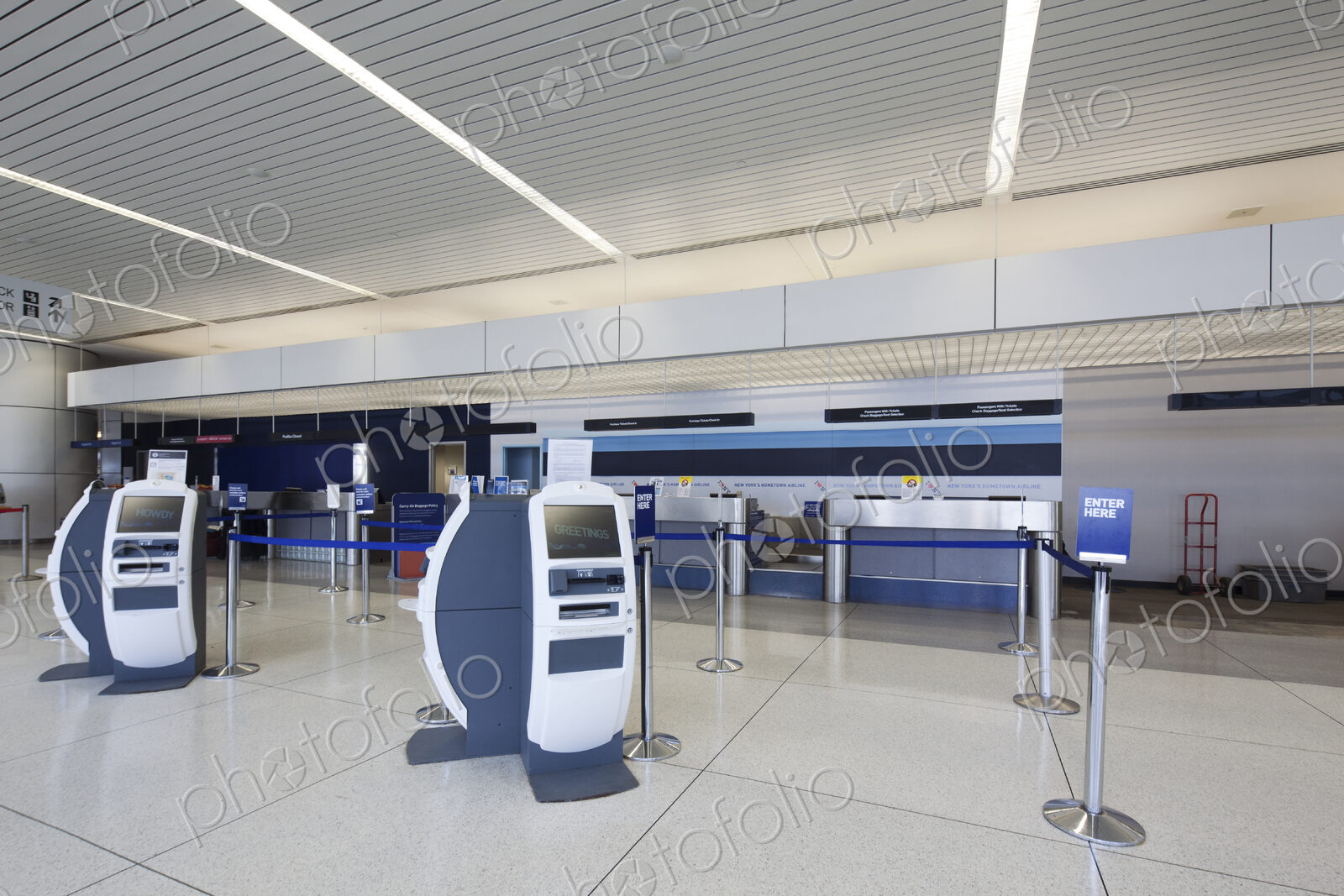 Self check-in desks and traditional baggage check in desks in an empty airport.