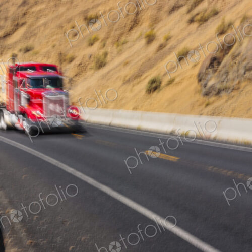 Semi-truck carrying a load driving fast on curvy mountain road, Yakima, WA USA