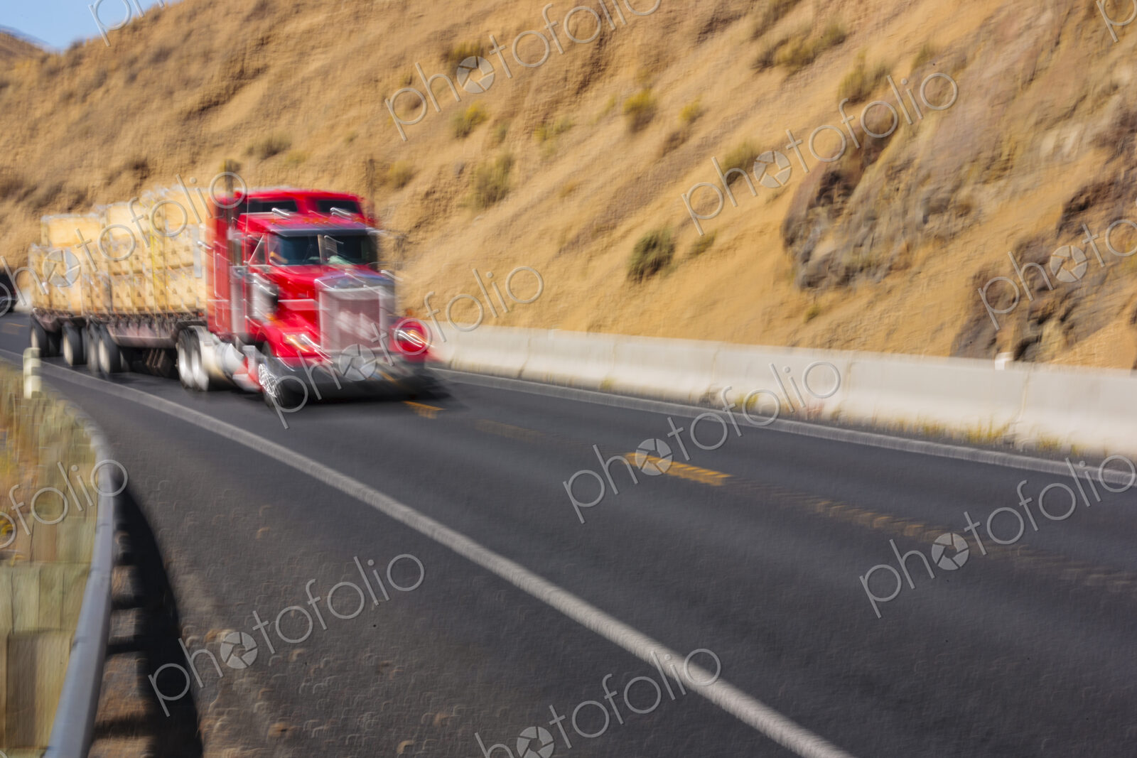 Semi-truck carrying a load driving fast on curvy mountain road, Yakima, WA USA