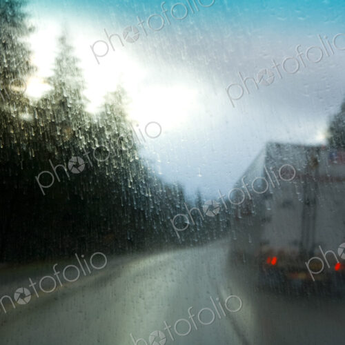 Semi-truck driving in heavy rain on an interstate highway through trees, Snoqualmie…