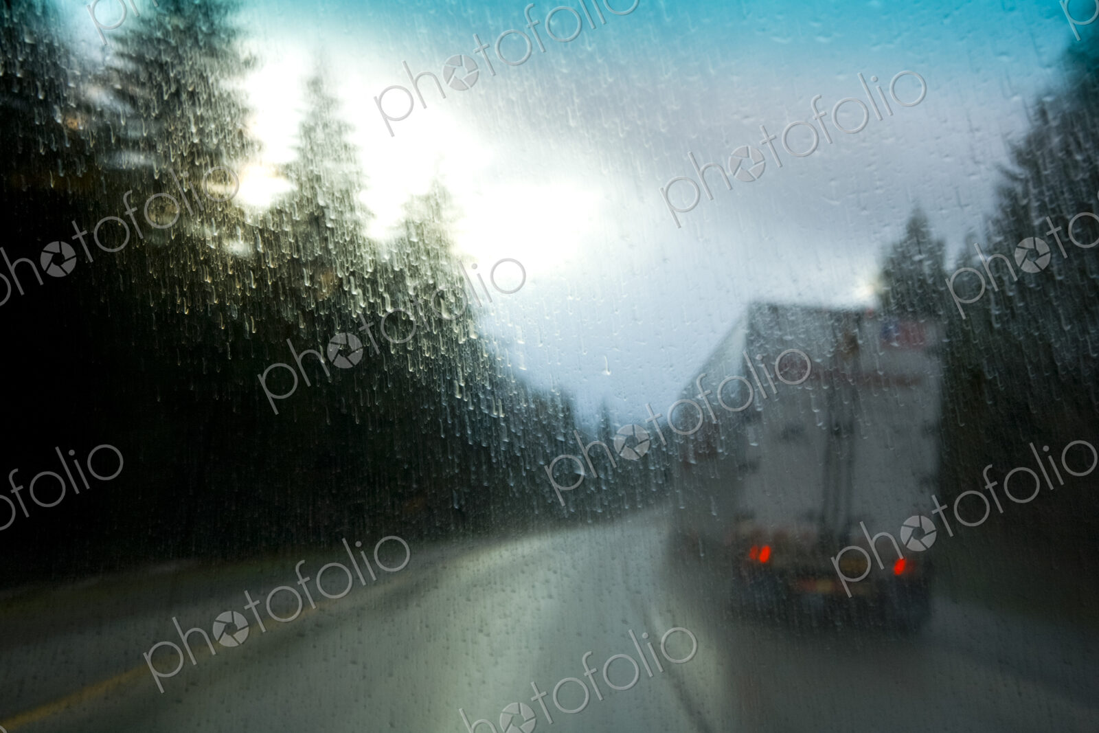 Semi-truck driving in heavy rain on an interstate highway through trees, Snoqualmie…