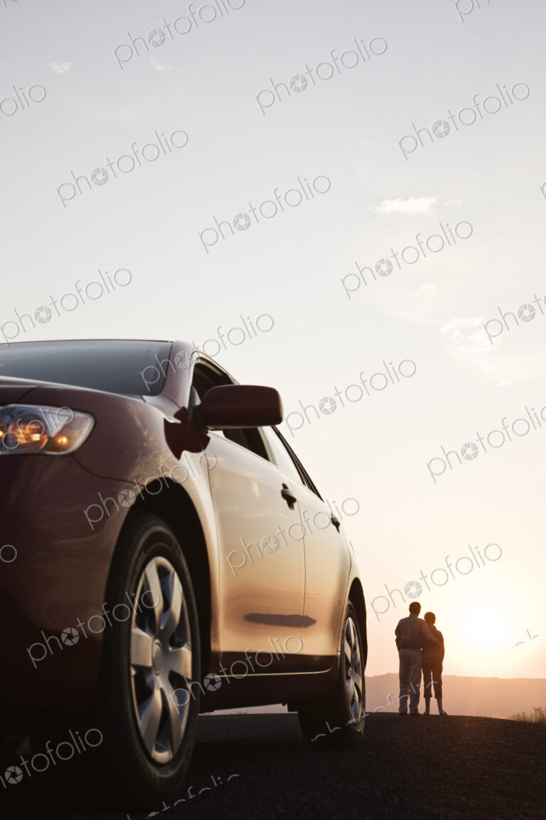Senior couple watching a sunset from a rest stop on a road trip in eastern Washington…