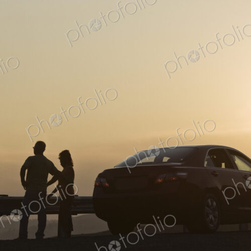 Senior couple watching a sunset from a rest stop on a road trip in eastern Washington…