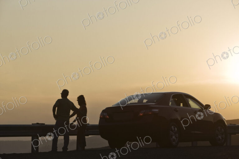 Senior couple watching a sunset from a rest stop on a road trip in eastern Washington…
