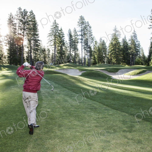 Senior golfer hitting a second shot from the fairway of a golf course. Senior golfer hitting a second shot from the fairway of a golf course.