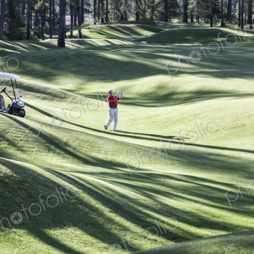 Senior golfer hitting a second shot from the fairway of a golf course. Senior golfer hitting a second shot from the fairway of a golf course.