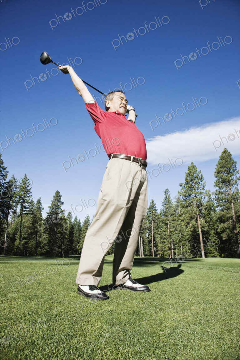 Senior golfer stretching with a golf club prior to playing a round of golf.