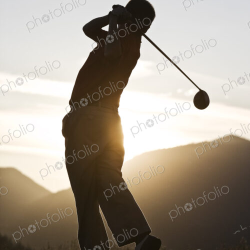 Senior golfer teeing off at sunset. Senior golfer teeing off at sunset.