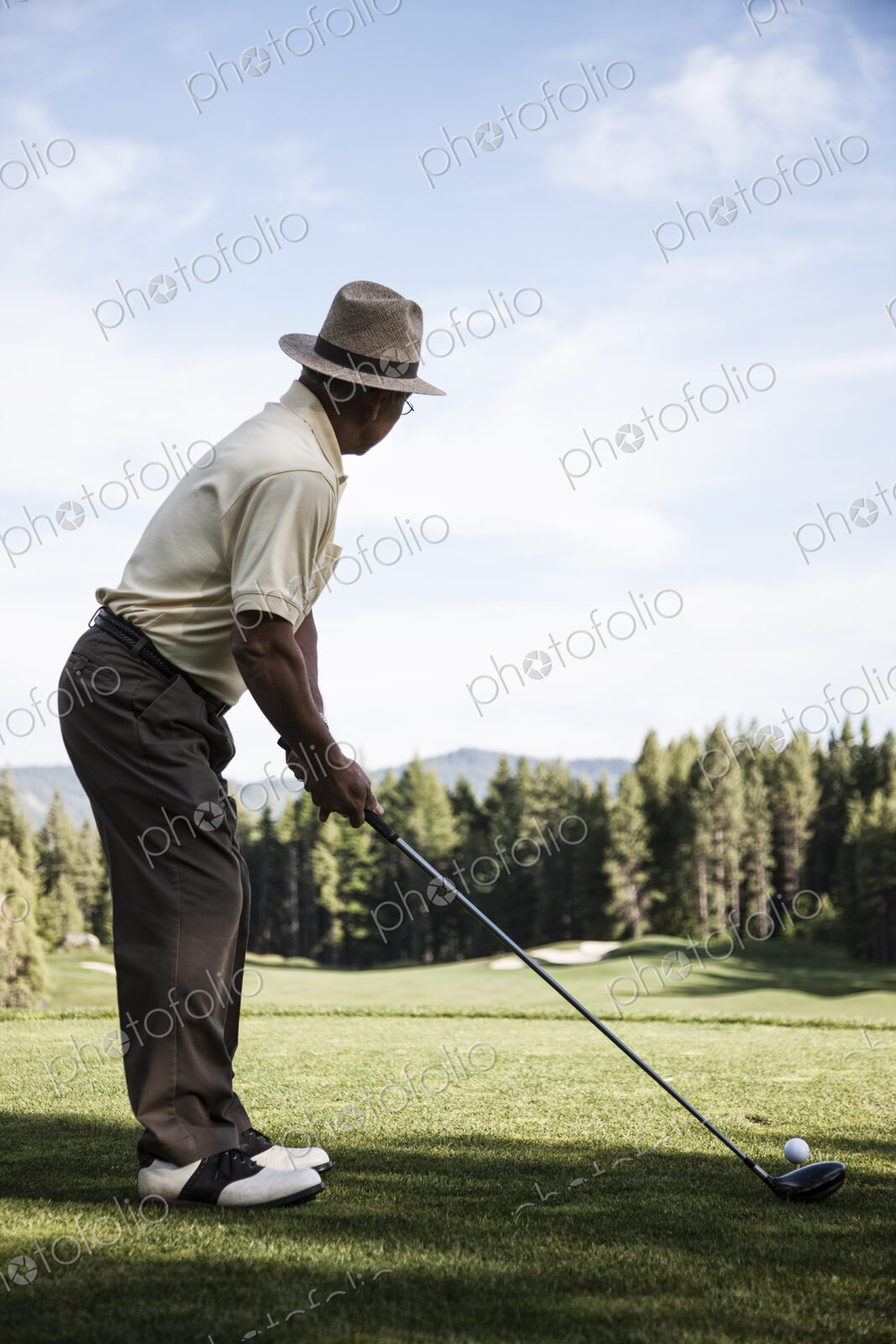 Senior golfer teeing off during a round of golf.