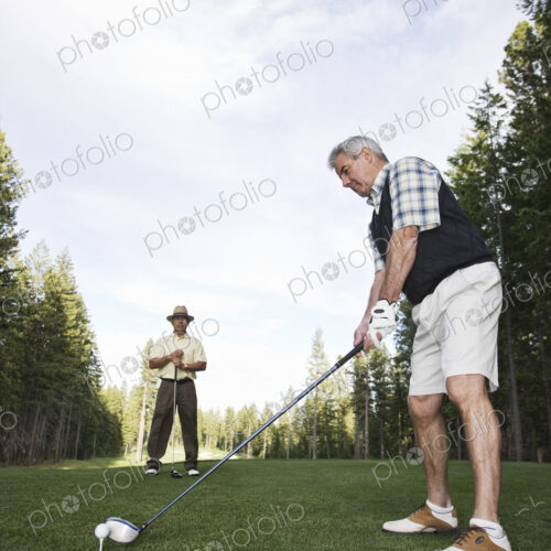 Senior golfer teeing off during a round of golf. Senior golfer teeing off during a round of golf.