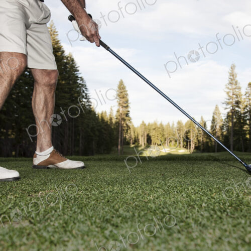 Senior golfer teeing off during a round of golf. Senior golfer teeing off during a round of golf.