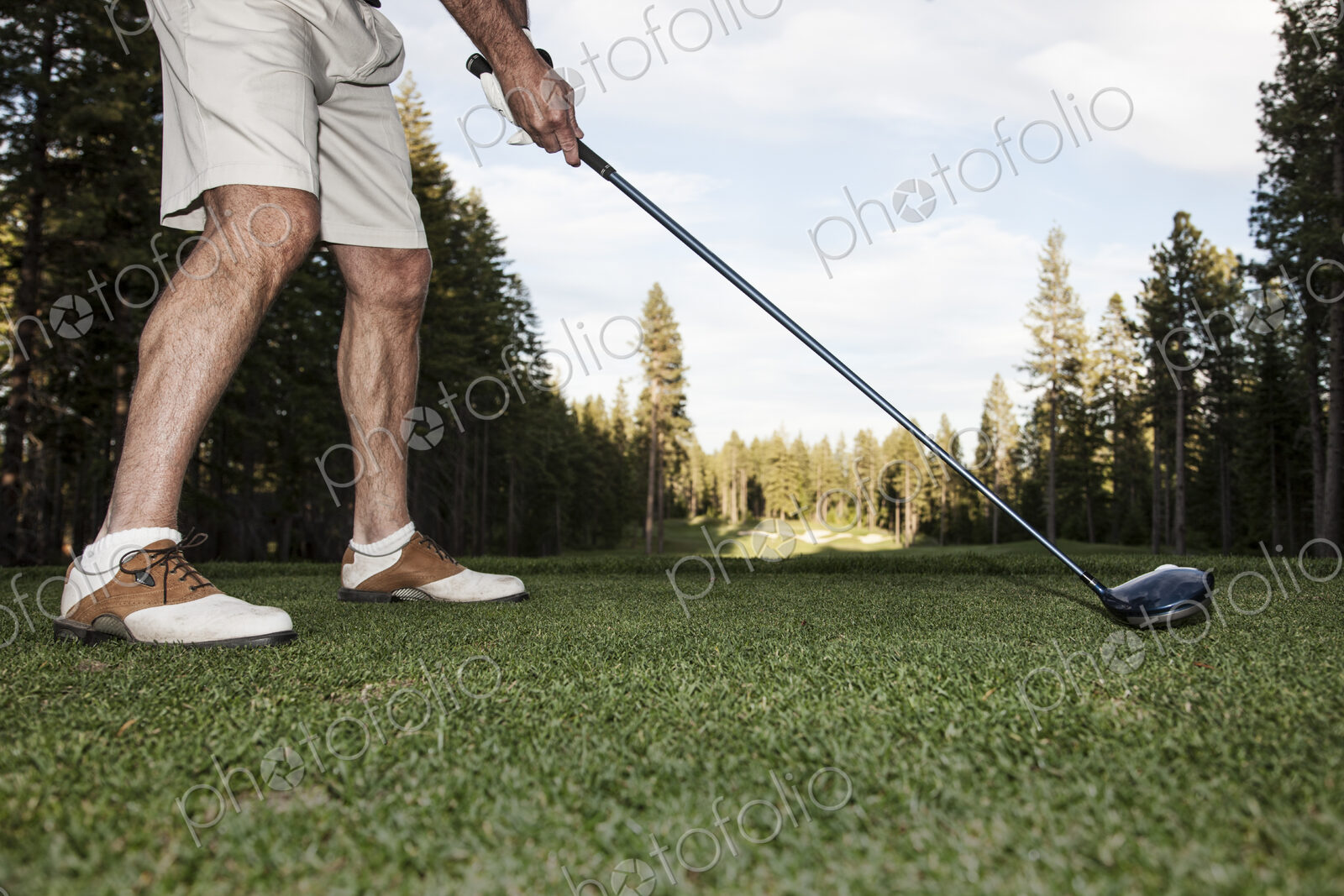Senior golfer teeing off during a round of golf.