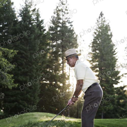 Senior golfer teeing off during a round of golf. Senior golfer teeing off during a round of golf.