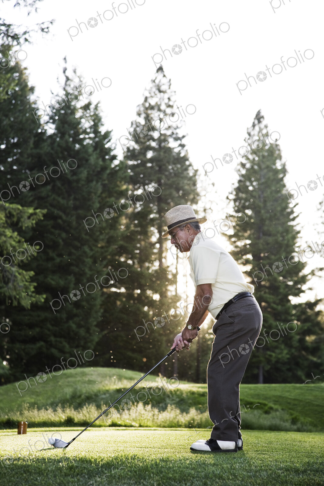 Senior golfer teeing off during a round of golf.