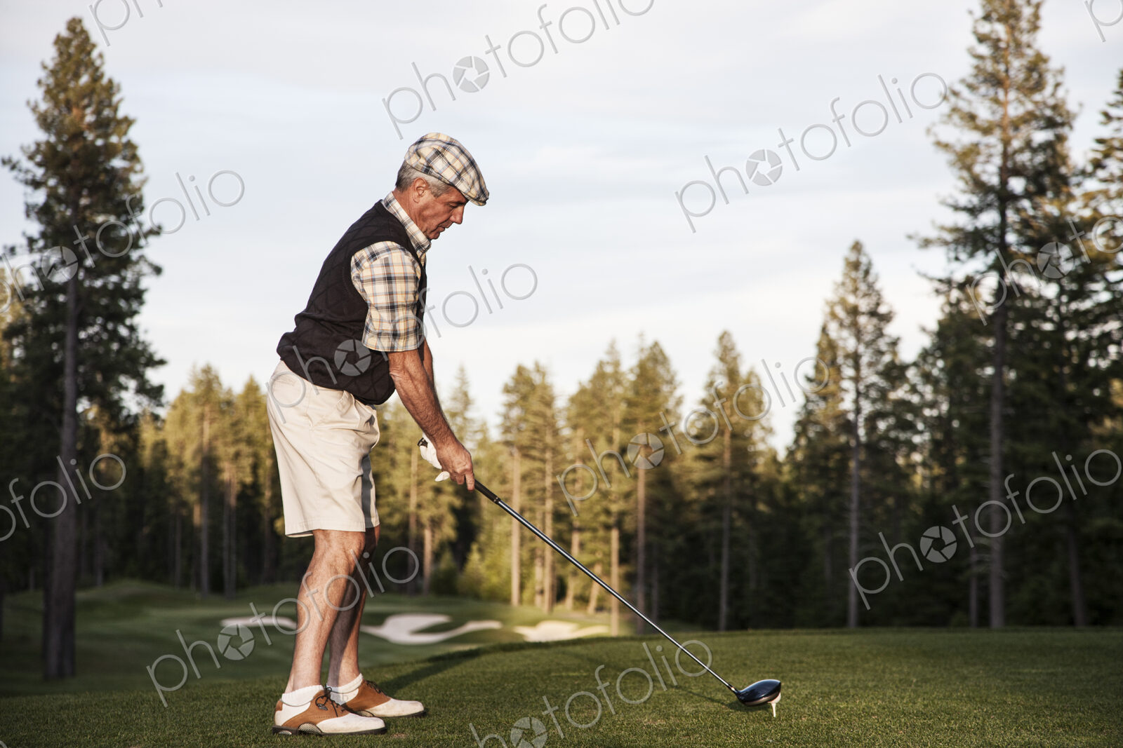 Senior golfer teeing off during a round of golf.
