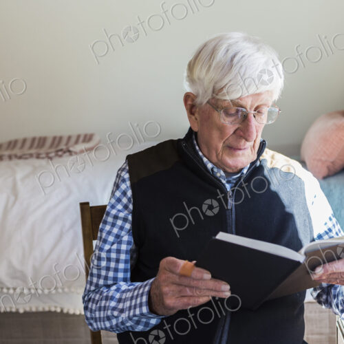 Senior man reading a book in his bedroom Senior man reading a book in his bedroom