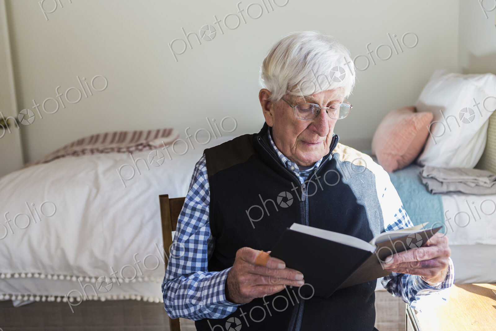 Senior man reading a book in his bedroom