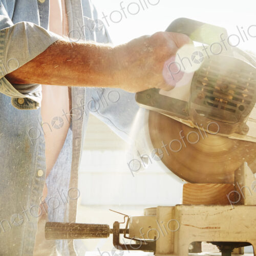 Senior man using a circular saw.
