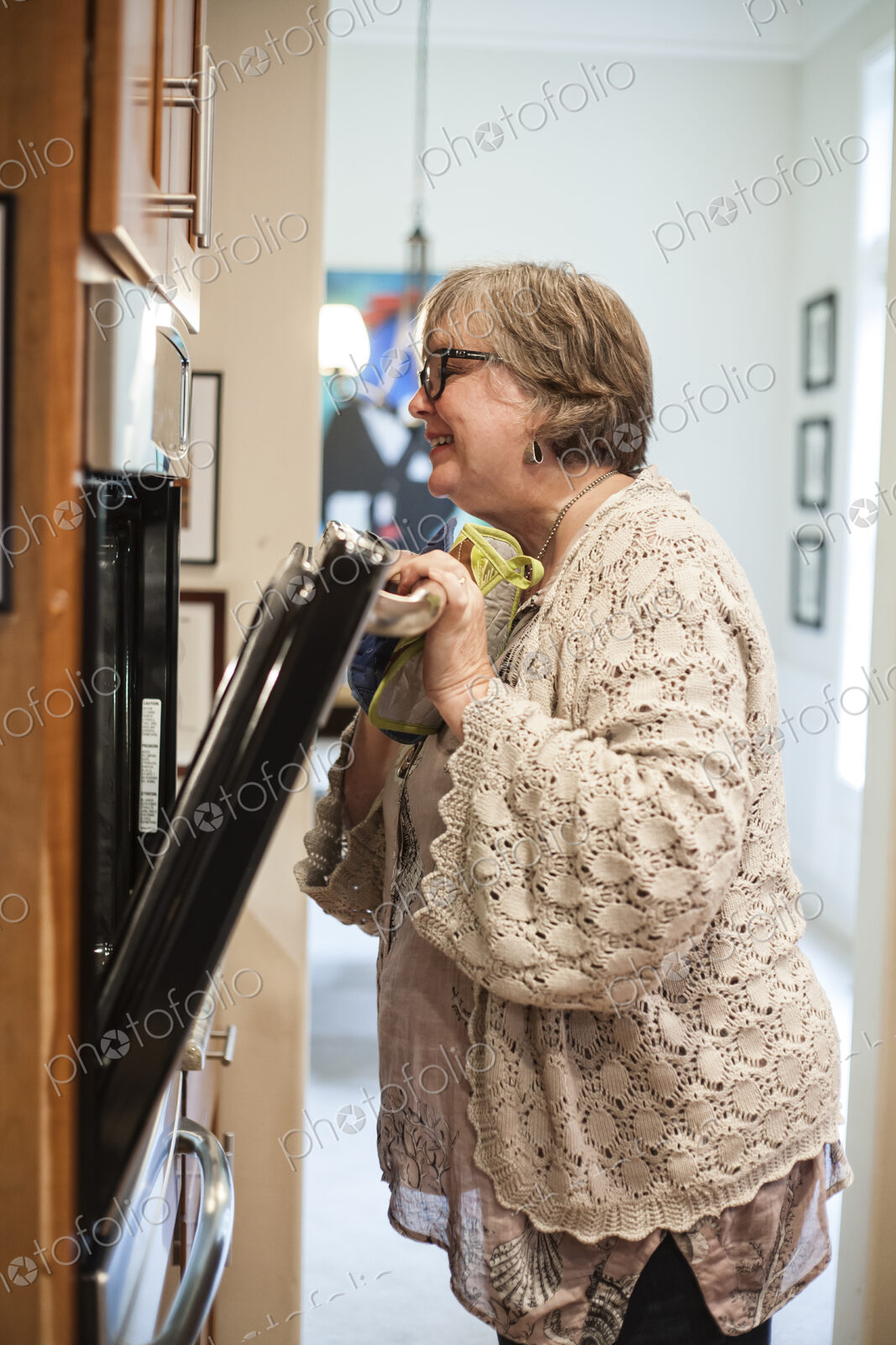 Senior woman checking in the oven to see if a dish is finished cooking.