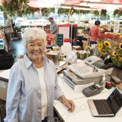 Senior woman standing at the checkout of a food and vegetable market, smiling at camera. Senior woman standing at the checkout of a food and vegetable market, smiling at camera.