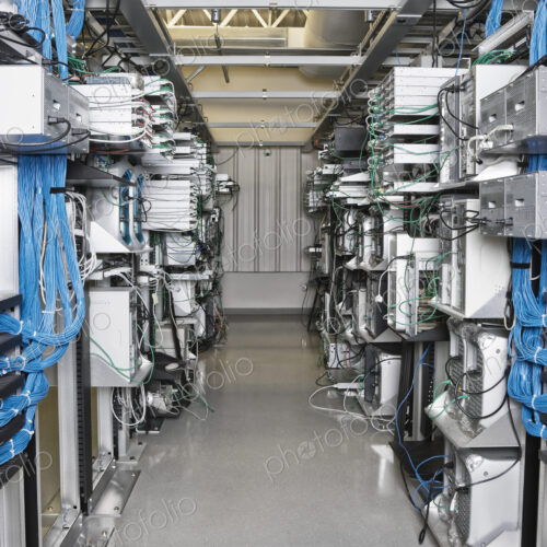 Server room aisle showing computer servers and CAT 5 cables. Server room aisle showing computer servers and CAT 5 cables.