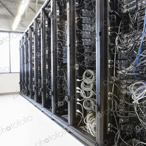 Servers in an aisle of racks in a computer server farm. Servers in an aisle of racks in a computer server farm.