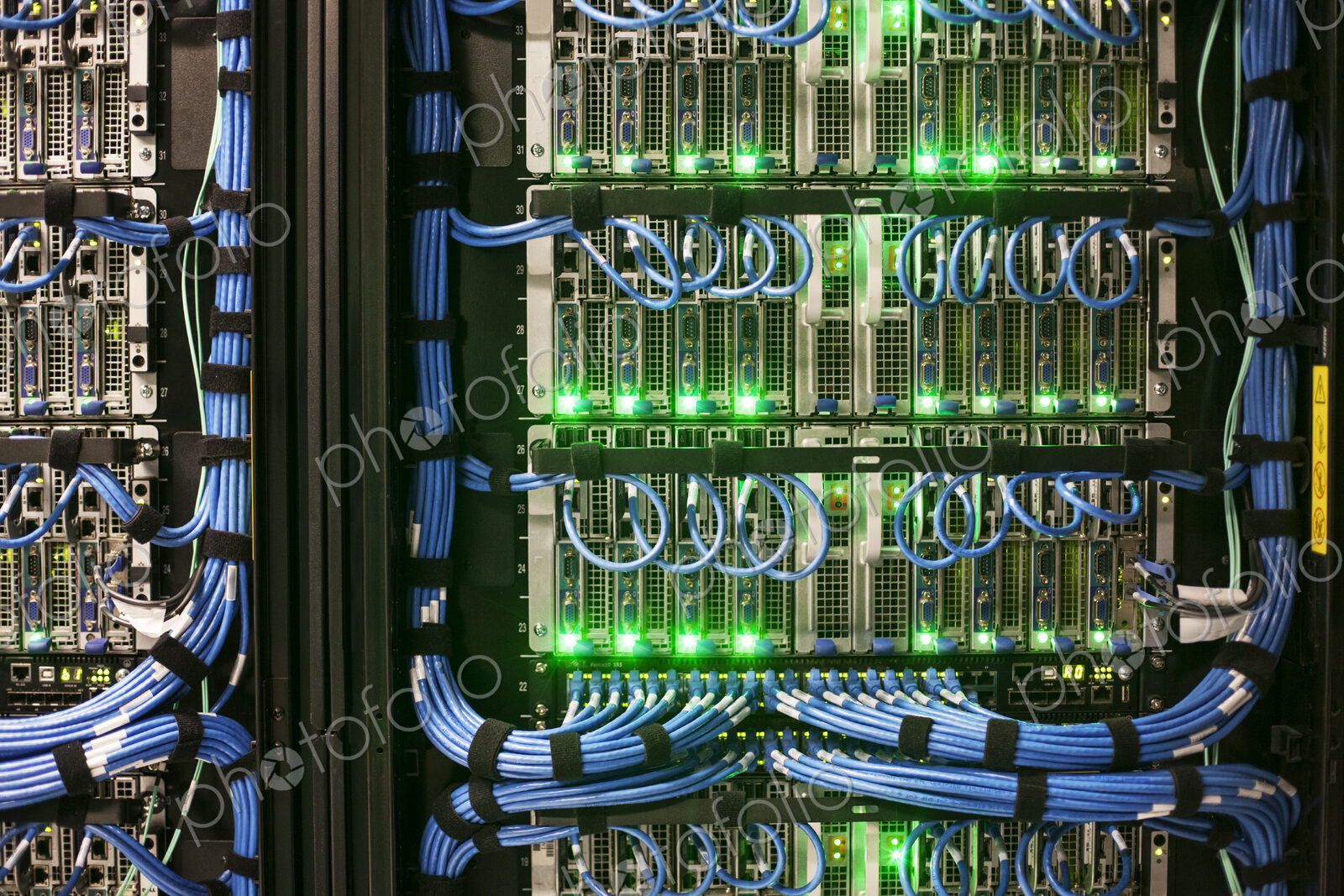 Servers with CAT 5 cables on racks in a large computer server farm.