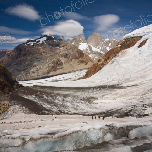 Several hikers on a glacier and Fitz Roy loom in the background. Los Glaciares… Several hikers on a glacier and Fitz Roy loom in the background. Los Glaciares…