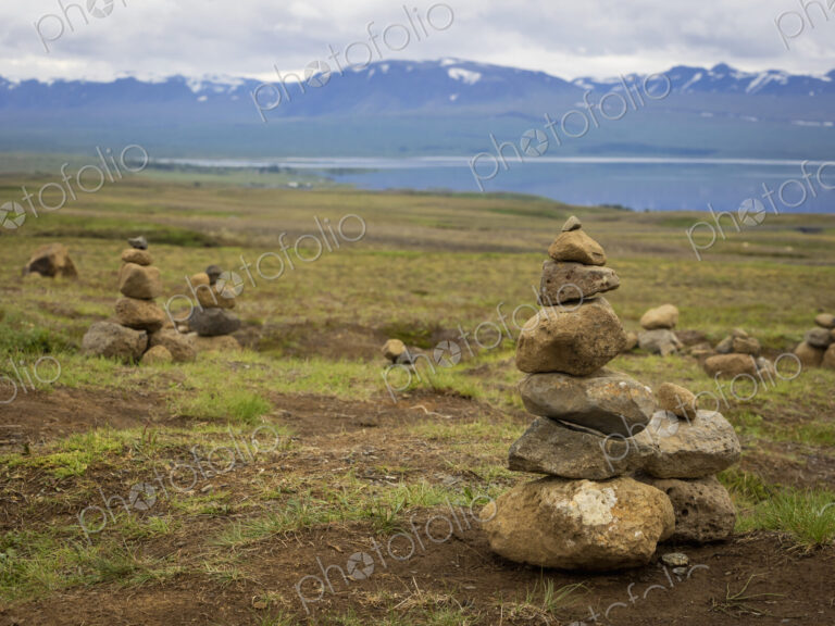 Several small stone cairns, made by balancing rocks in a pile.
