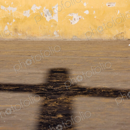 Shadow of a crucifix on a street pavement. Shadow of a crucifix on a street pavement.